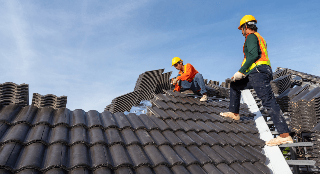Roofing team installing roof tiles